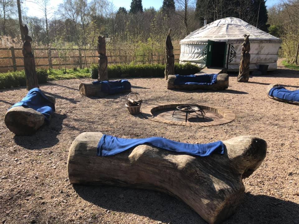 An outdoor fire circle beside a yurt